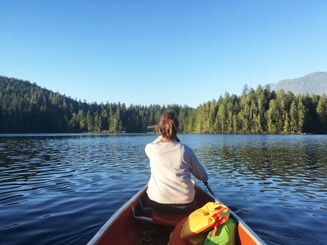 chica en canoa en un lago de Canadá